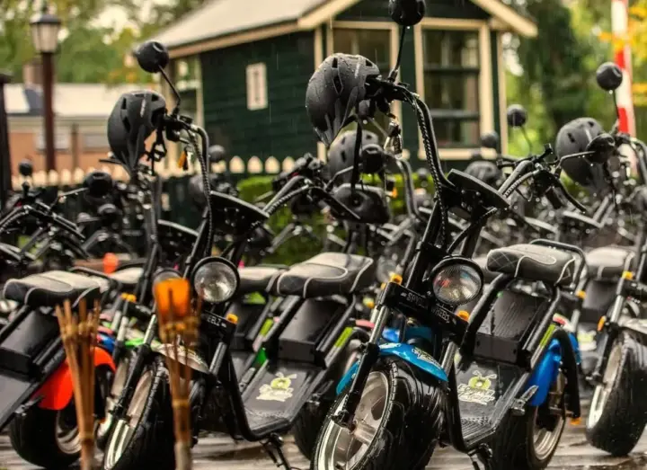Rij geparkeerde e-choppers met helmen in Boekelo, klaar voor een personeelsuitje nabij Enschede