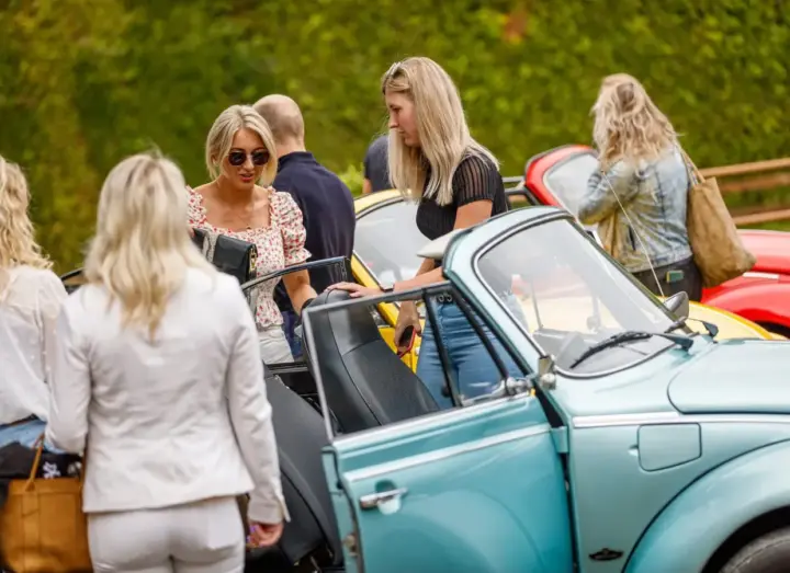 Collega's bij een lichtblauwe VW Kever Cabrio tijdens een personeelsuitje nabij Hengelo